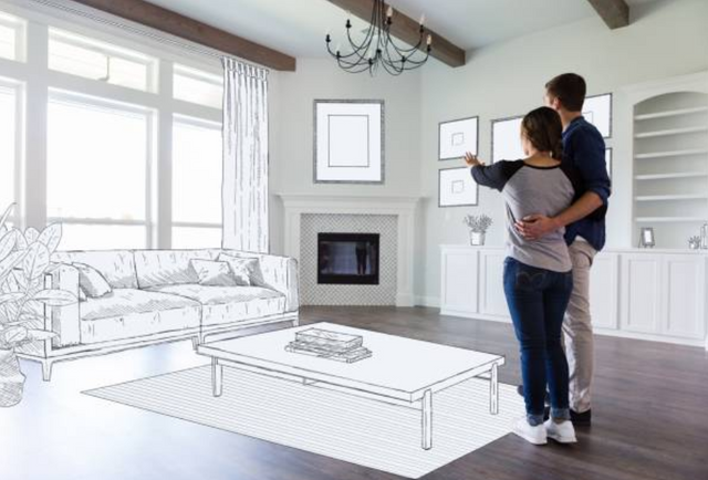 front view of a man and woman standing together envisioning a furnished and decorated living room, with the half they are facing morphed into a black and white sketch of home furnishings and decor
