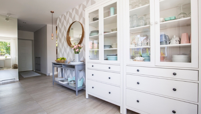 A large white hutch storing dishes in a kitchen/dining room.
