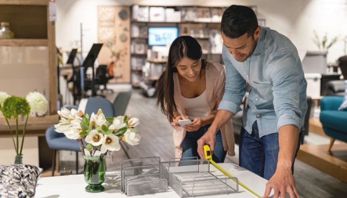 Couple measuring furniture in store