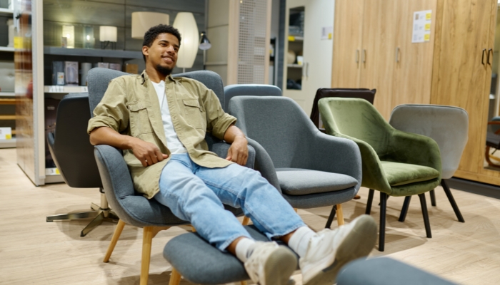 Man testing out a chair and stool in store