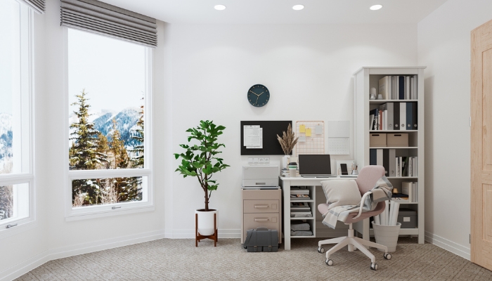 A well-organized home office with a comfy pillow, blanket, filing cabinet, plants, and bookcase, and use vertical wall space