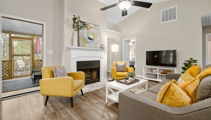 A neutral modern living room with yellow accents.