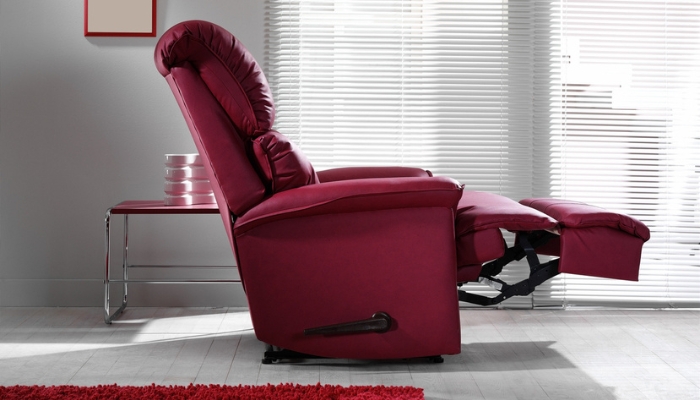 A purple recliner with the footrest up sits in a gray living room.