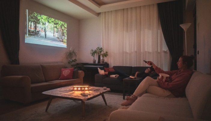 Two friends binge-watching with snacks, side tables, and mood lighting