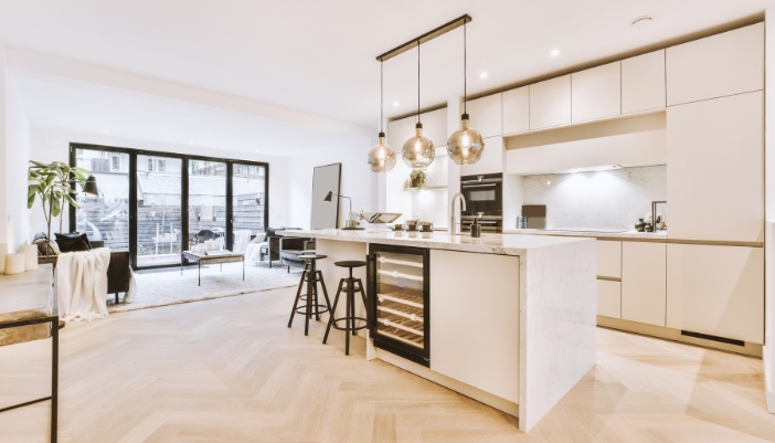 A bright, white apartment with an open concept living room/kitchen.