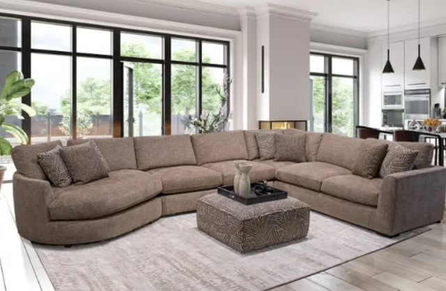 front view of a brown sectional sofa with deep large seats to relax in. The sectional sits in a modern open concept living room with large windows on the wall behind