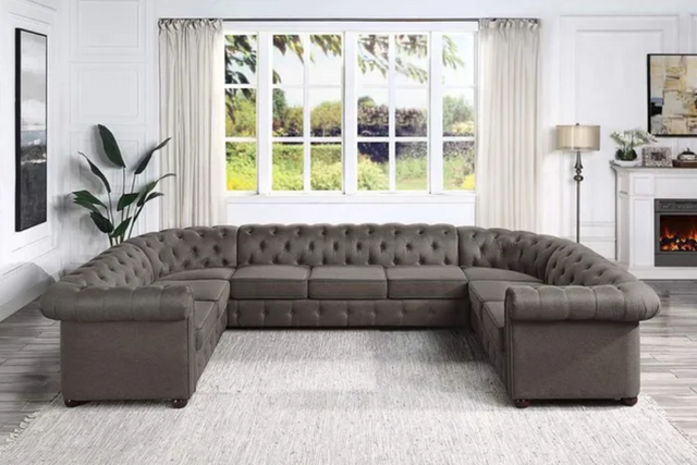 front view of a traditional ornate and tufted grey leather u shaped sectional