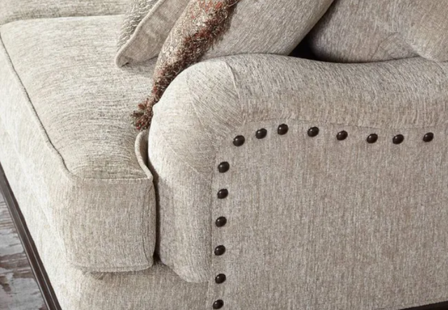 side view of a white linen tufted sofa arm and seat