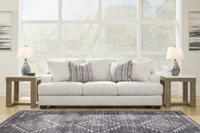 front view of a modern white sofa with end tables on either side and a large window in the background