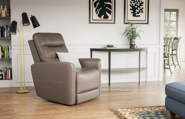 front view of a modern living room with white walls, light wooden floors, and a light brown flexsteel recliner with an accent pillow on it