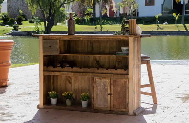 front view of a wooden home bar outside next to a pond