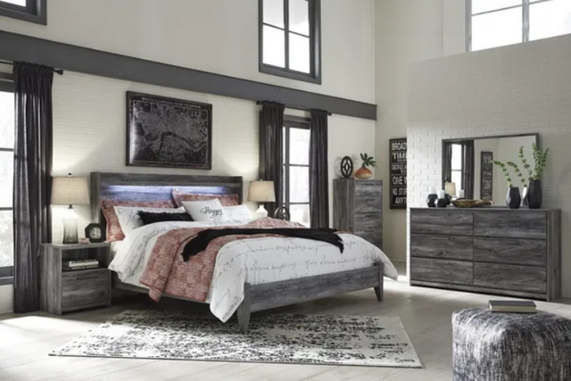 view of a transitional bedroom with a grey wooden king bed frame and matching furniture throughout