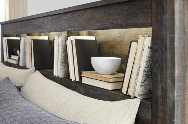 close view of a modern king bookcase bed headboard with various books and decor in it