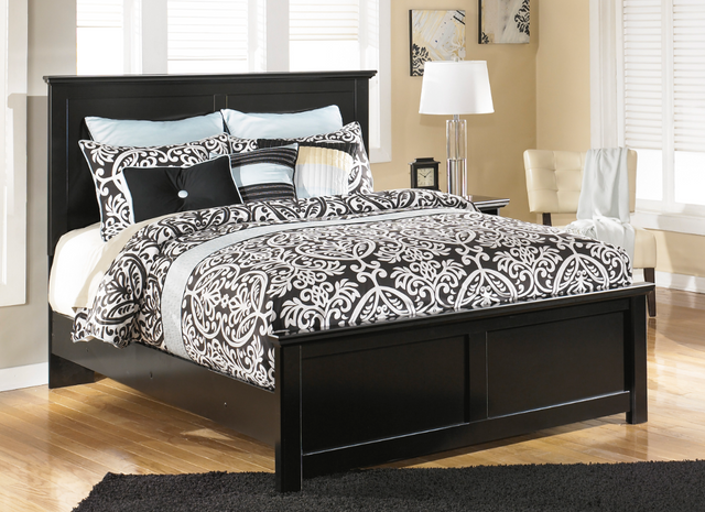 front view of a transitional bedroom with a black king bed frame and a mattress with a black and white comforter