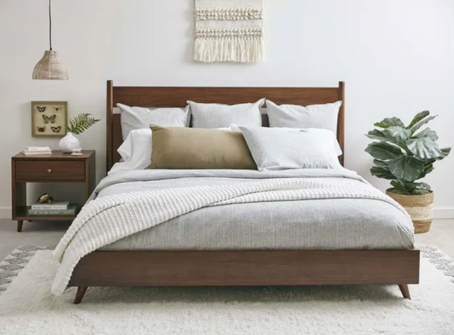 front view of a casual bedroom with a wooden full bed frame and mattress
