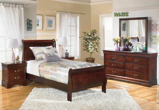 view of a traditional style kids bedroom with beige walls and wooden furniture, including a twin panel bed