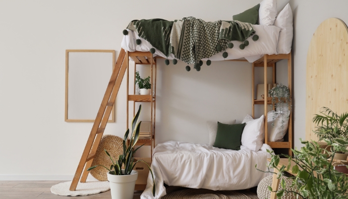 A set of wooden bunk beds in a neutral children’s room. 
