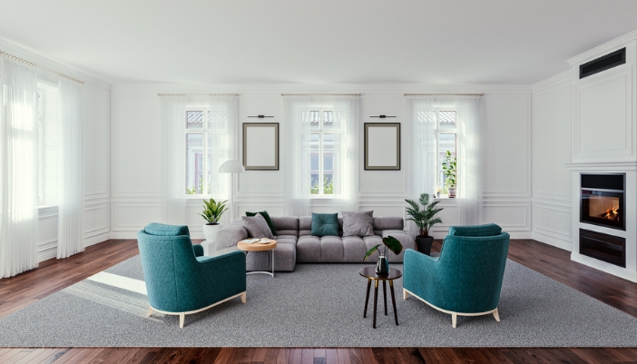 A modern living room with a modular gray sofa and a pair of blue armchairs.