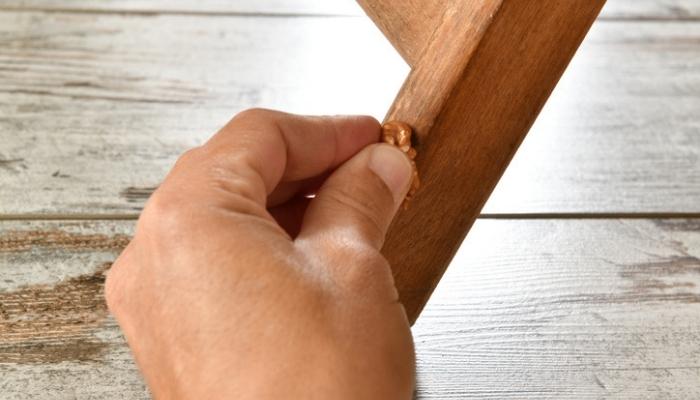 person using walnut to fix wood