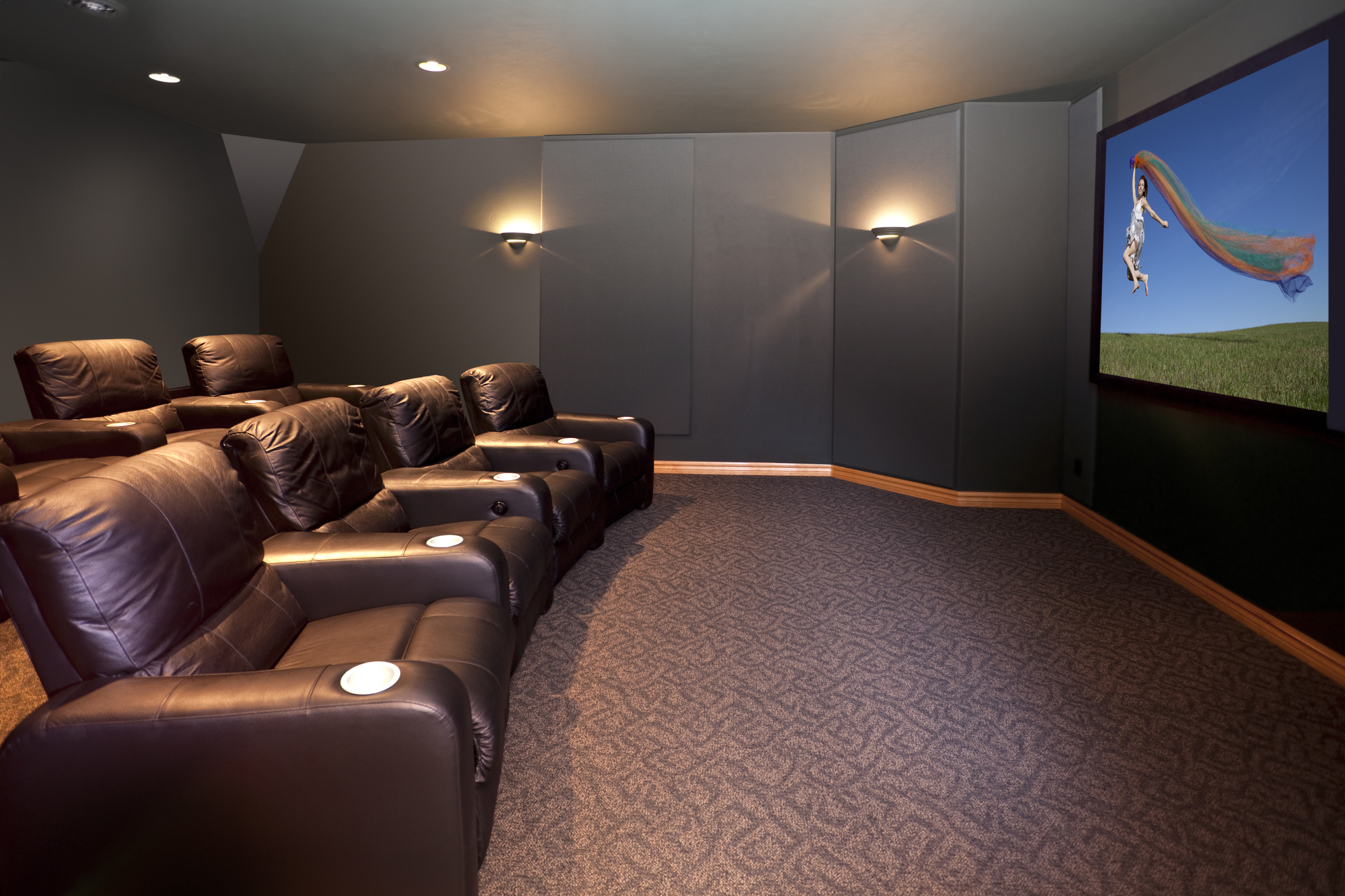 side view of home theater with rows of brown recliners 