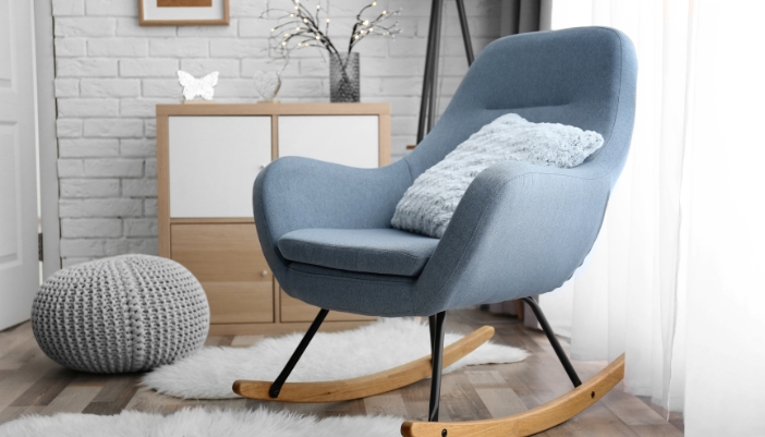 Closeup of a rocking accent chair and throw pillow on top