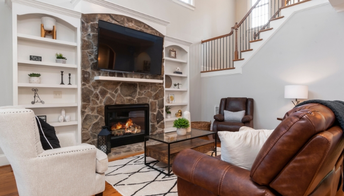 TV mounted above fireplace with a mantle heat shield and recliners facing it