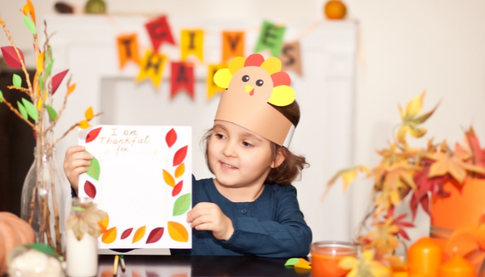 Little kid creating thanksgiving notes at kids corner