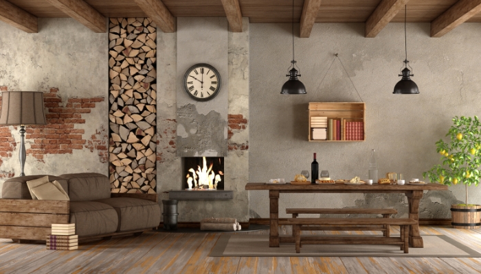 A rustic living room/dining room with exposed wood panels, rustic light fixtures, and a lemon tree