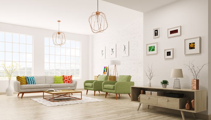 A brighly lit living room with a light gray couch and a pair of green armchairs. 