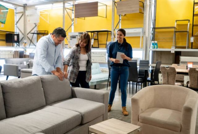 salesperson helping two people choose a sofa
