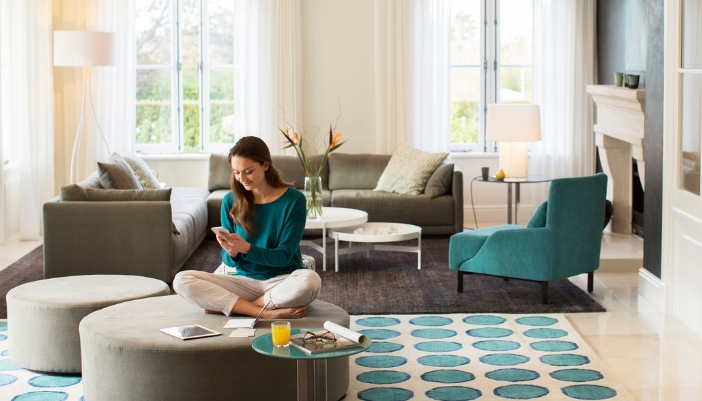 Woman sitting on a round ottoman while working on her hobby