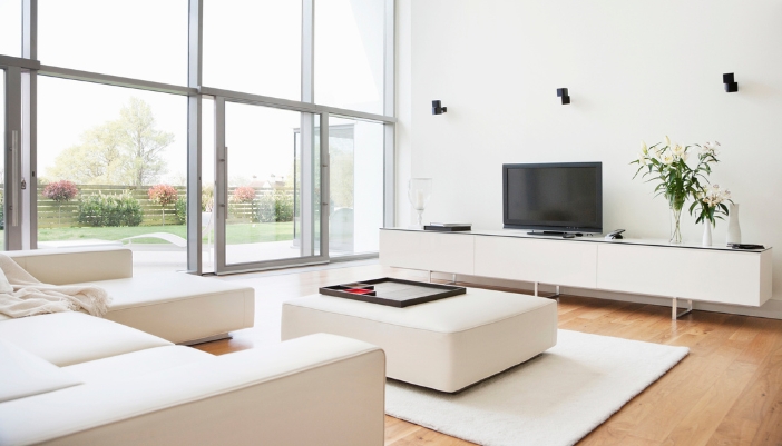 A modern living room with a cocktail ottoman and tray in front of a sofa with chaise