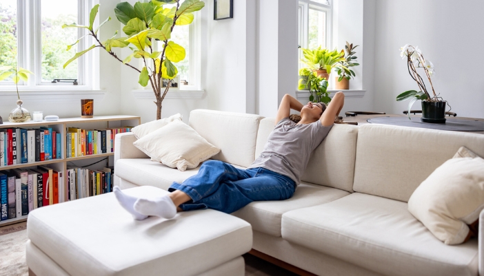 Woman relaxing on her sofa with her feet on top of the ottoman