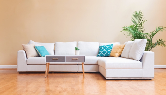A neutral sectional sofa sits in a modern living room.