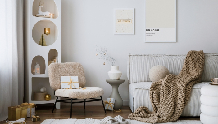 A living room with subtle white and gold holiday decorations.