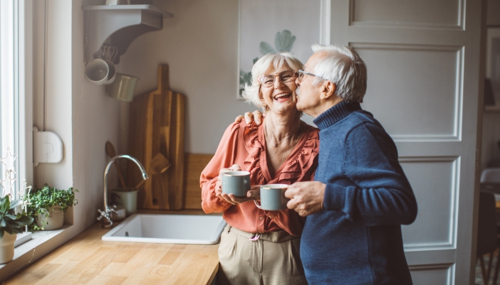 elderly couple enjoying coffee in their kitchen