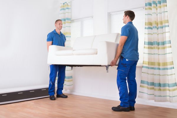 Two delivery men carrying a sofa 