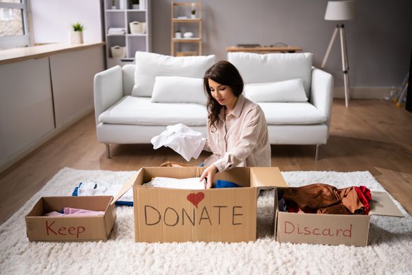 A woman organizing items to keep, donate, or discard 