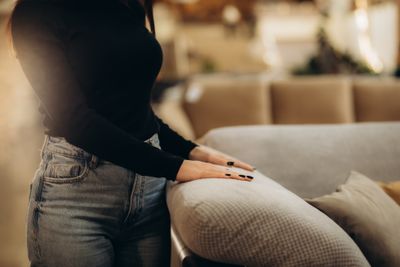 A woman touching a sofa