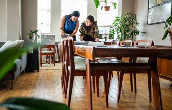 iStock Credit: NickyLloyd A long shot of two smiling woman at the end of a table