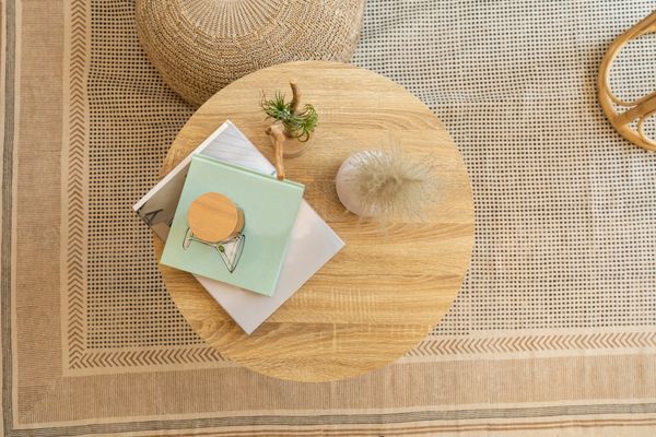 An aerial shot of a round wooden coffee table with décor 