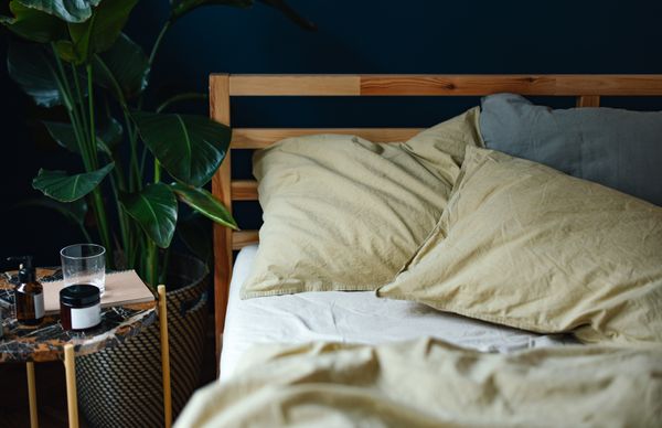A close-up of a wooden slat bed with décor 