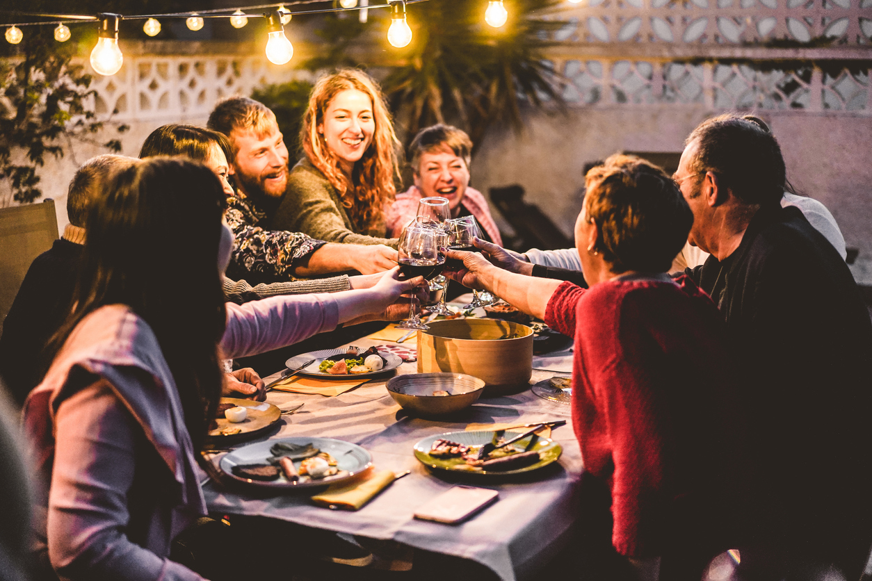 happy family cheering with red wine at barbecue dinner outdoor