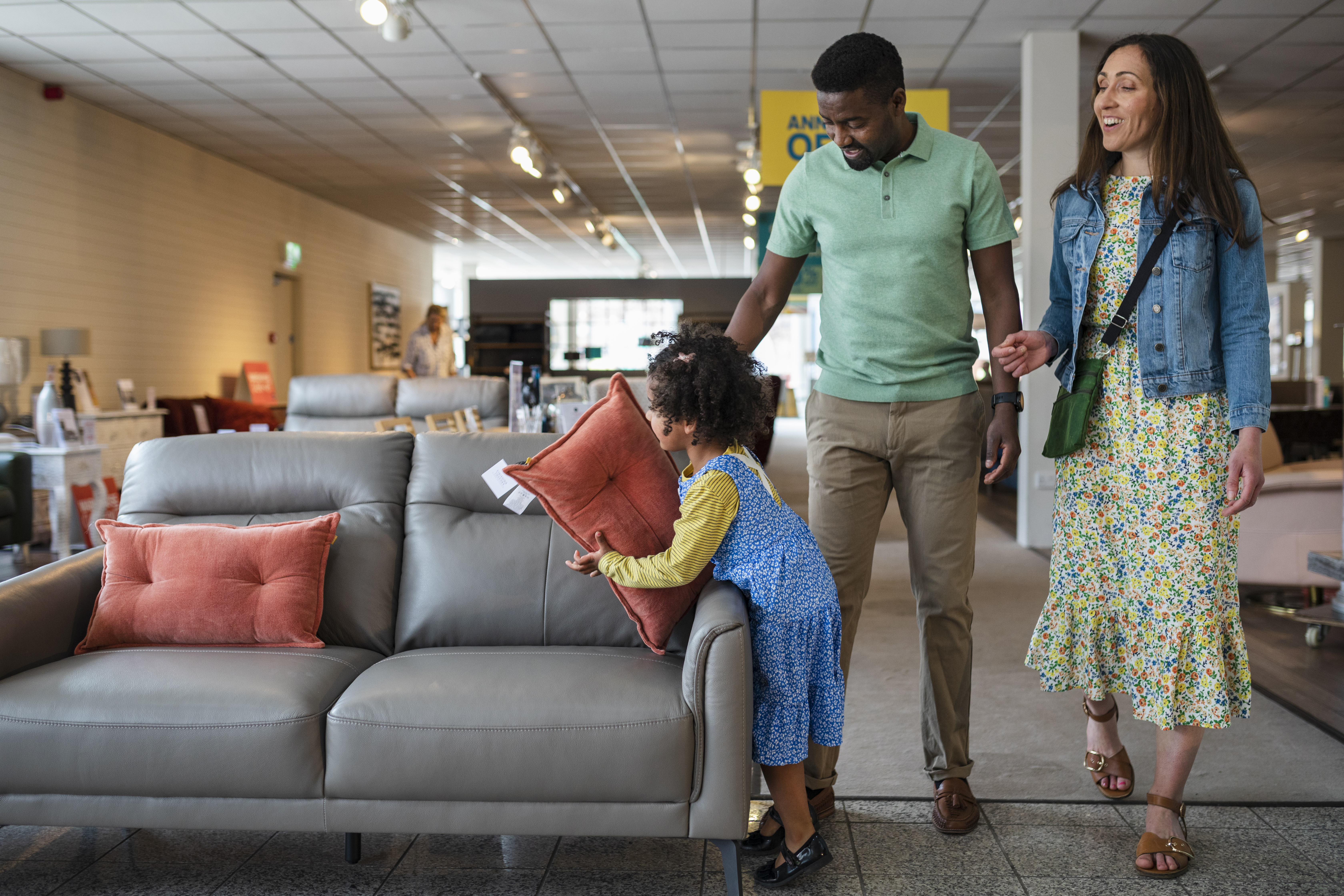 A family of three shopping for a sofa in a furniture store 