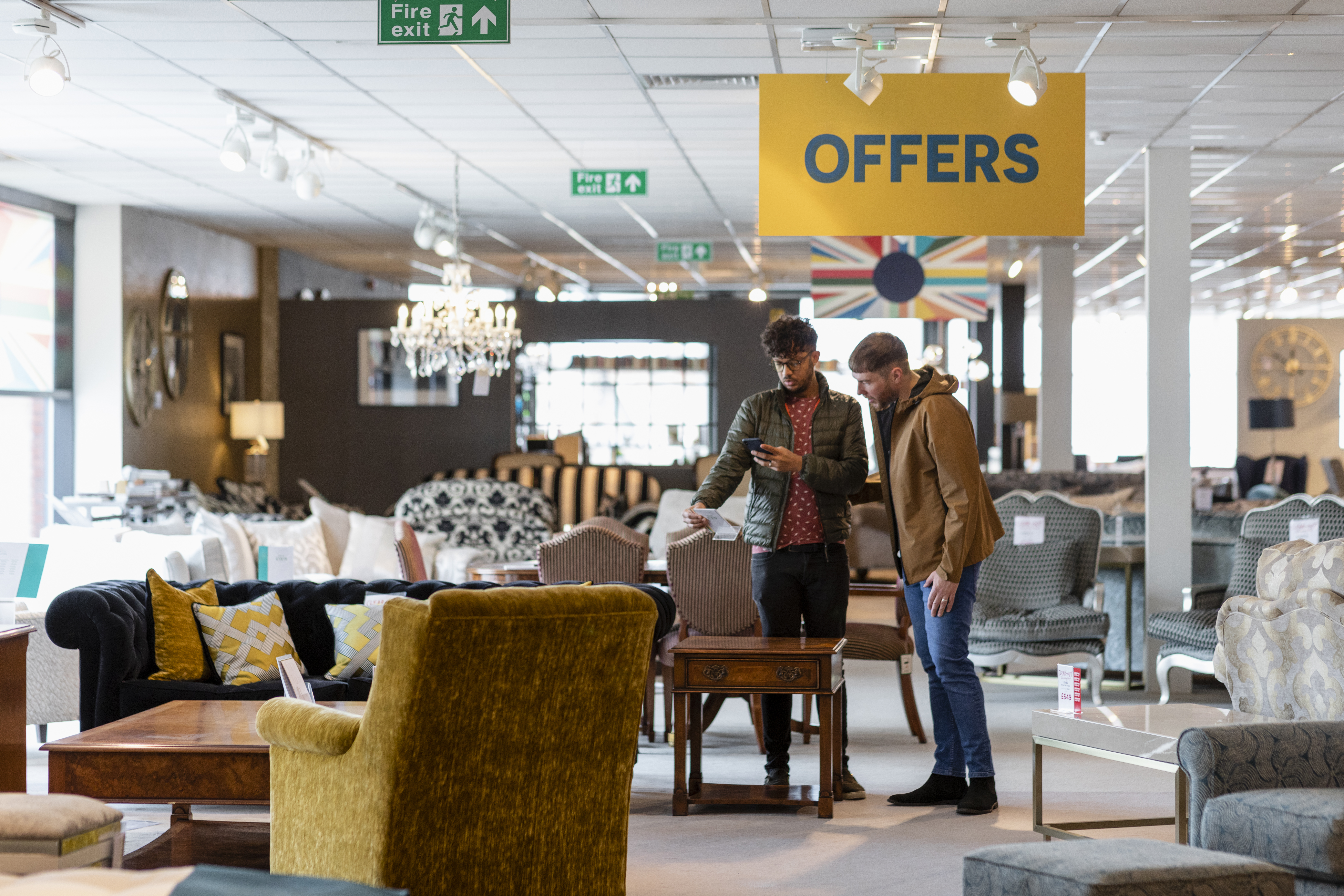 Two young men shopping the clearance section at a furniture store 