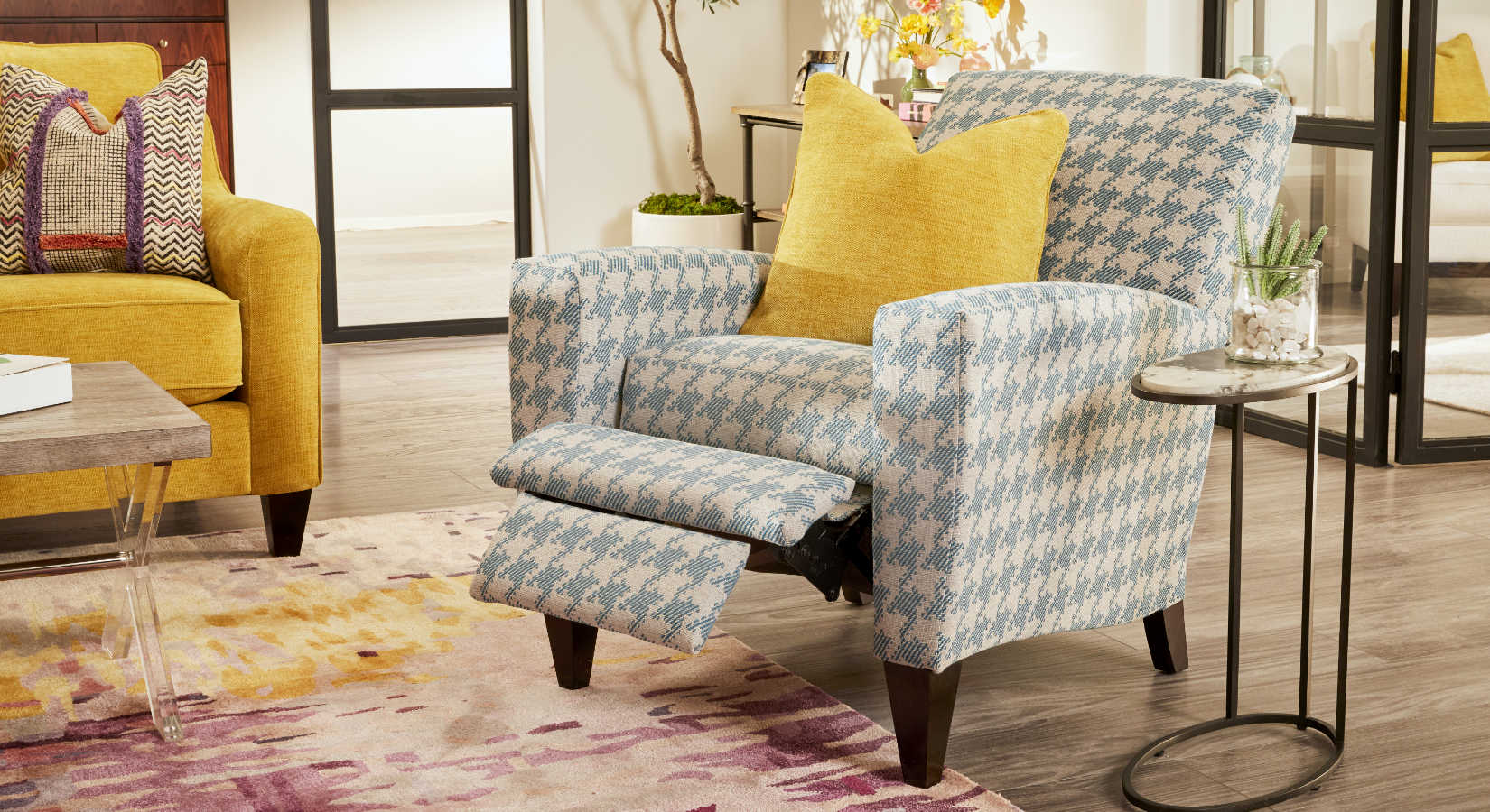A La-Z-Boy high leg recliner in a houndstooth upholstery with a yellow accent pillow