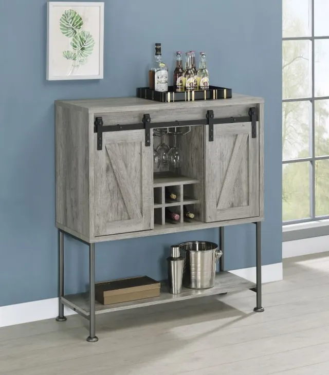 The Coaster Grey Driftwood bar cabinet against a blue wall 