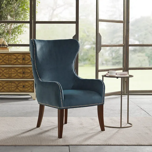 The Olliix John Blue accent chair in front of glass doors 