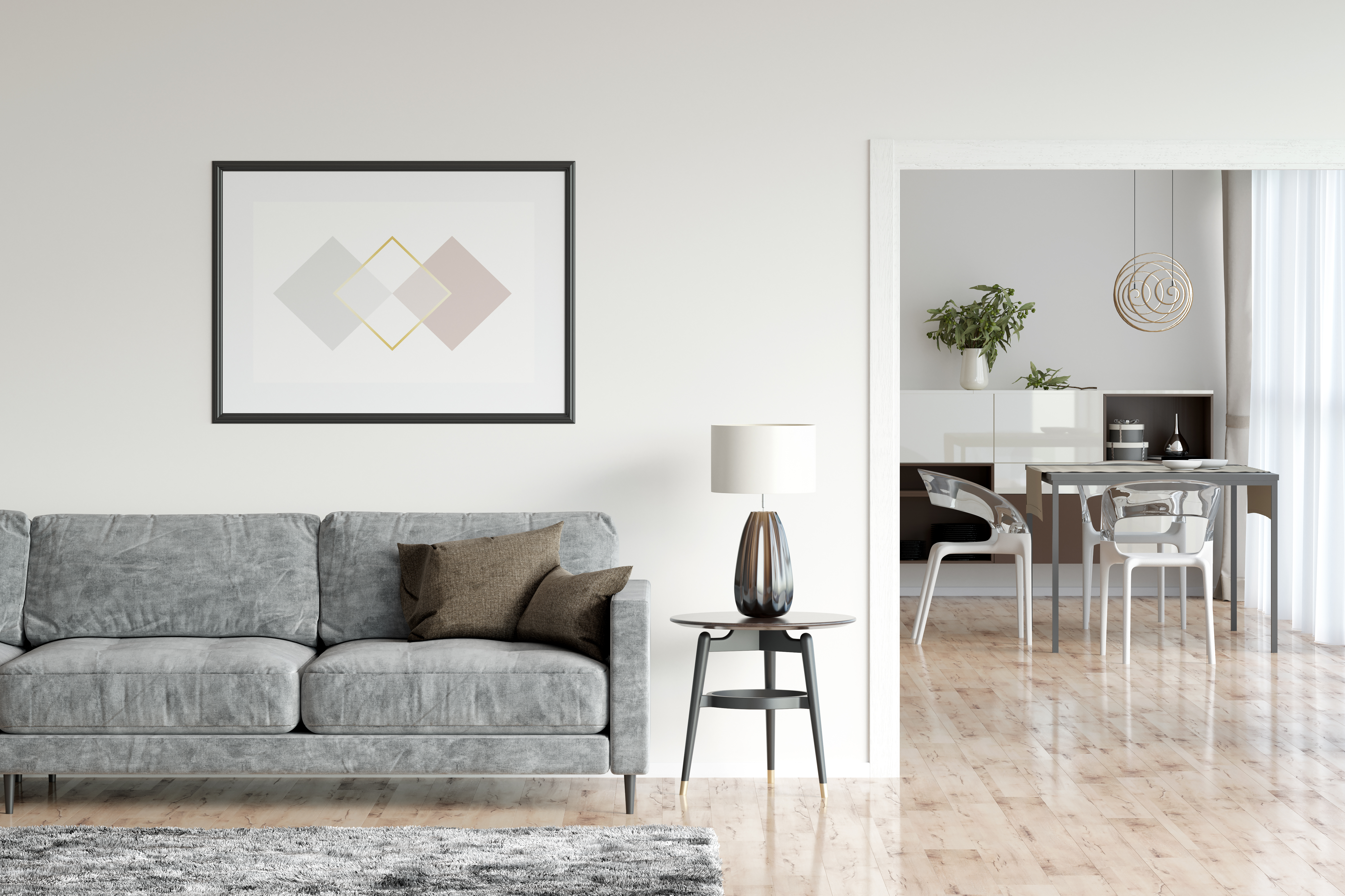 A grey sofa next to a living room pathway leading to a dining room 