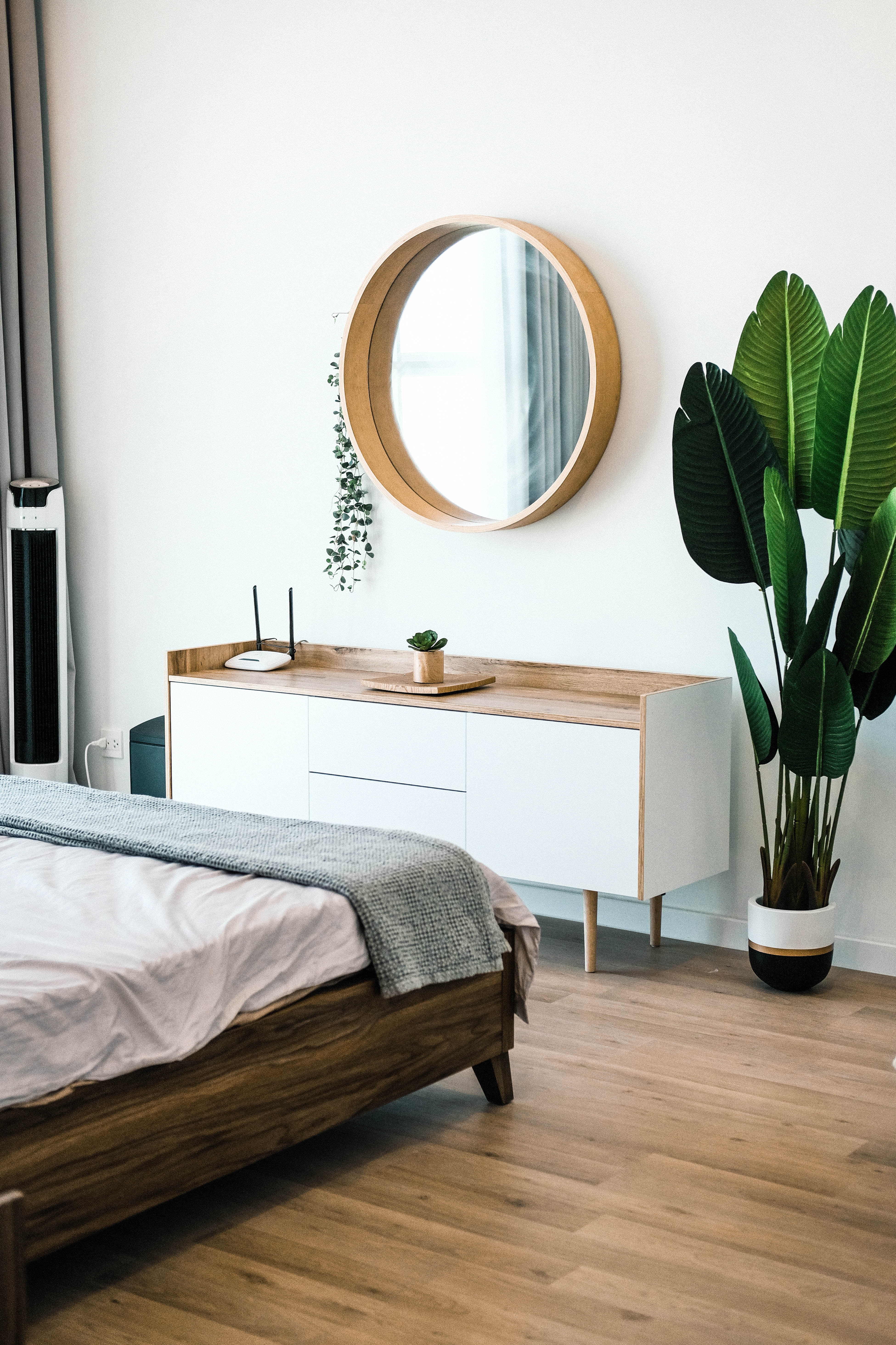 White wooden dresser with plant and mirror